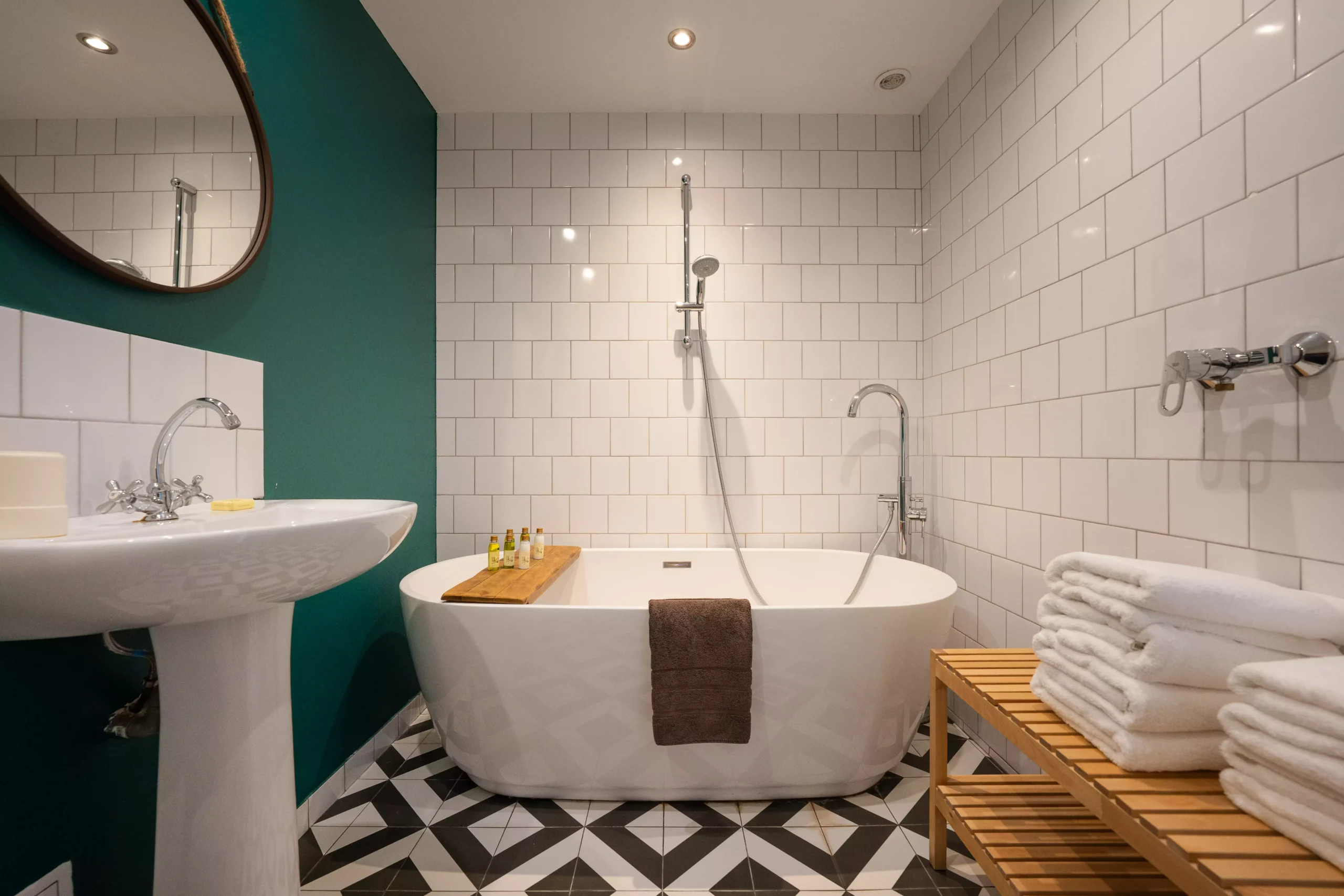 Villa Le Perchoir - Grande baignoire blanche à rebords hauts et serviettes.