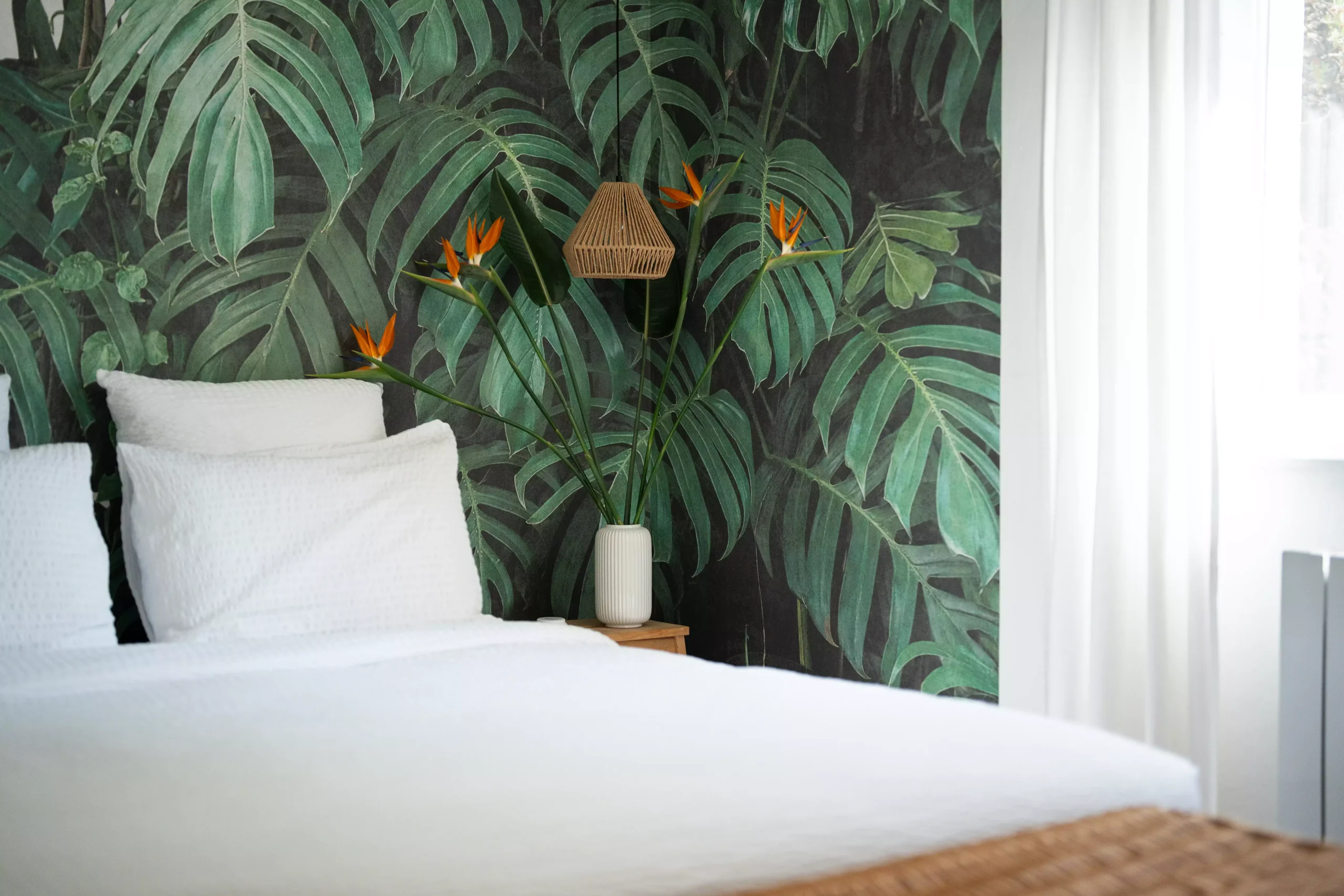 Villa Le Perchoir - Chambre avec papier peint de feuilles de monstera.