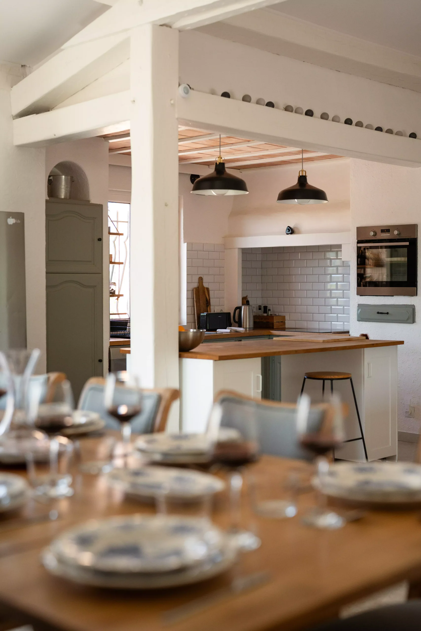 Villa Le Perchoir - Cuisine ouverte avec îlot central bois et salle à manger.