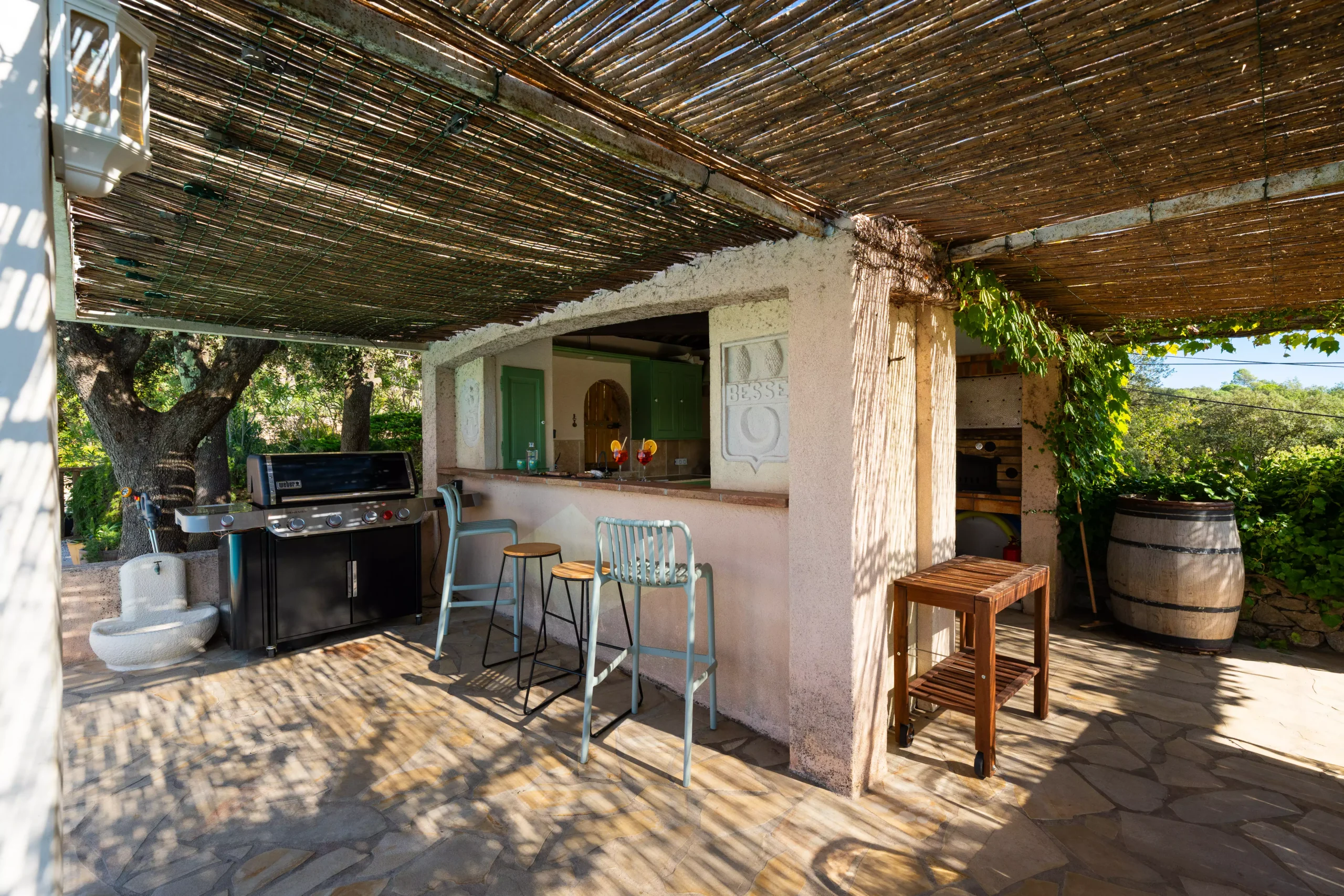 Villa Le Perchoir - Vue extérieur de la cuisine d'été et de son barbecue de la marque Weber.
