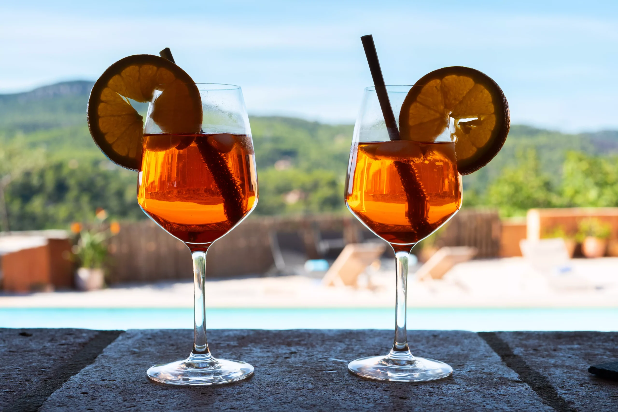 Villa Le Perchoir - Deux cocktails orangés sur le bar extérieur proche de la piscine.